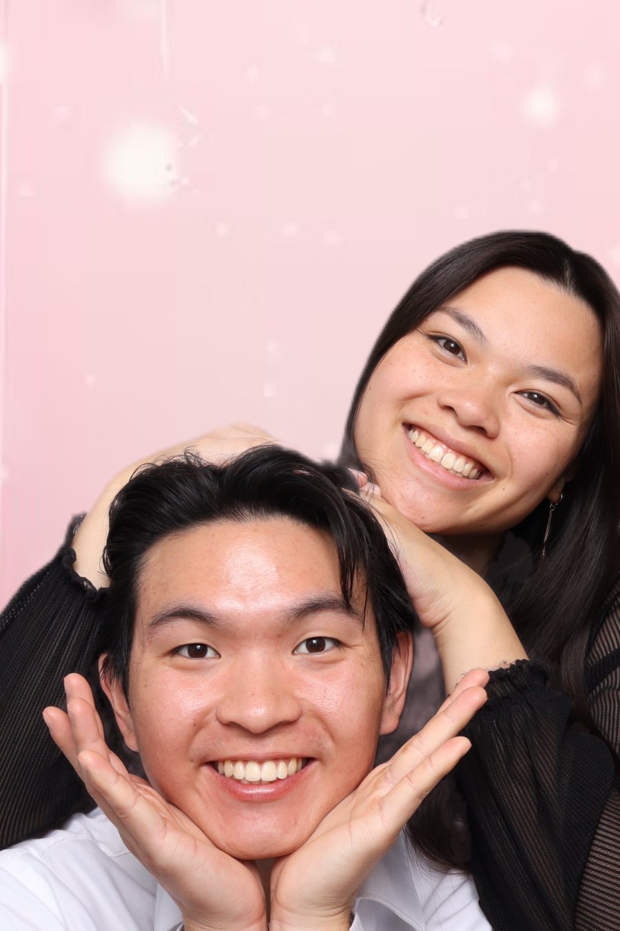Two guests in front of a balloon backdrop in the Stella Booth