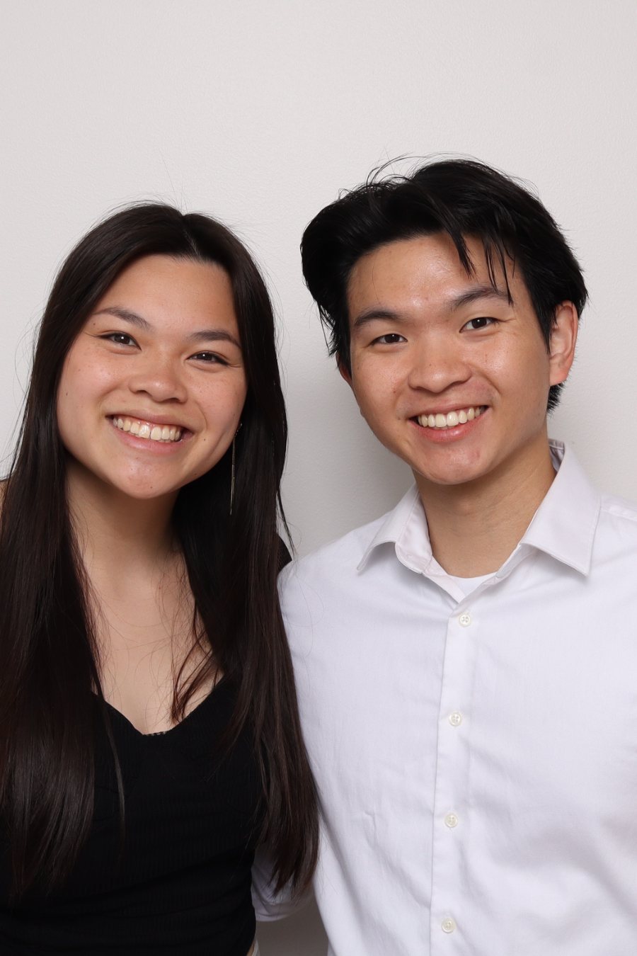 Two guests posing together in the Stella Booth against a clean white backdrop