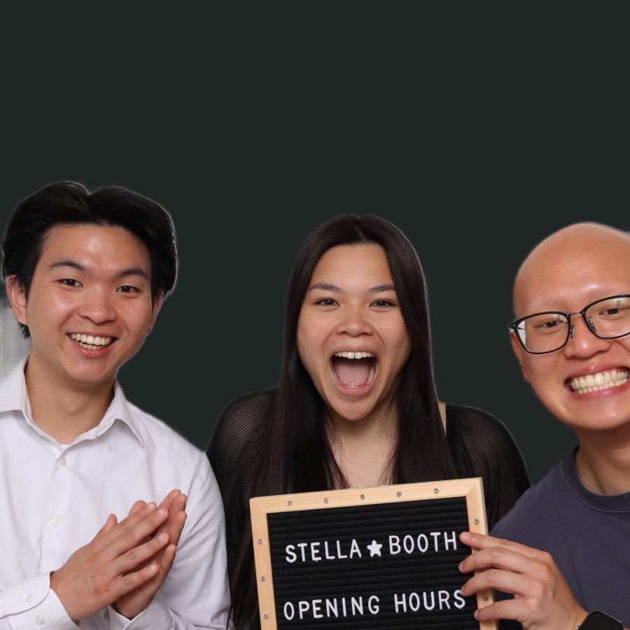Three guests holding a Stella Booth letterboard sign
