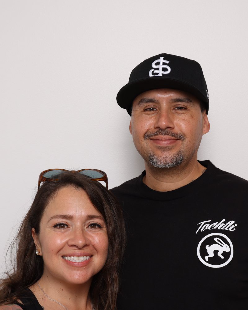A couple smiling side by side in the Stella Booth